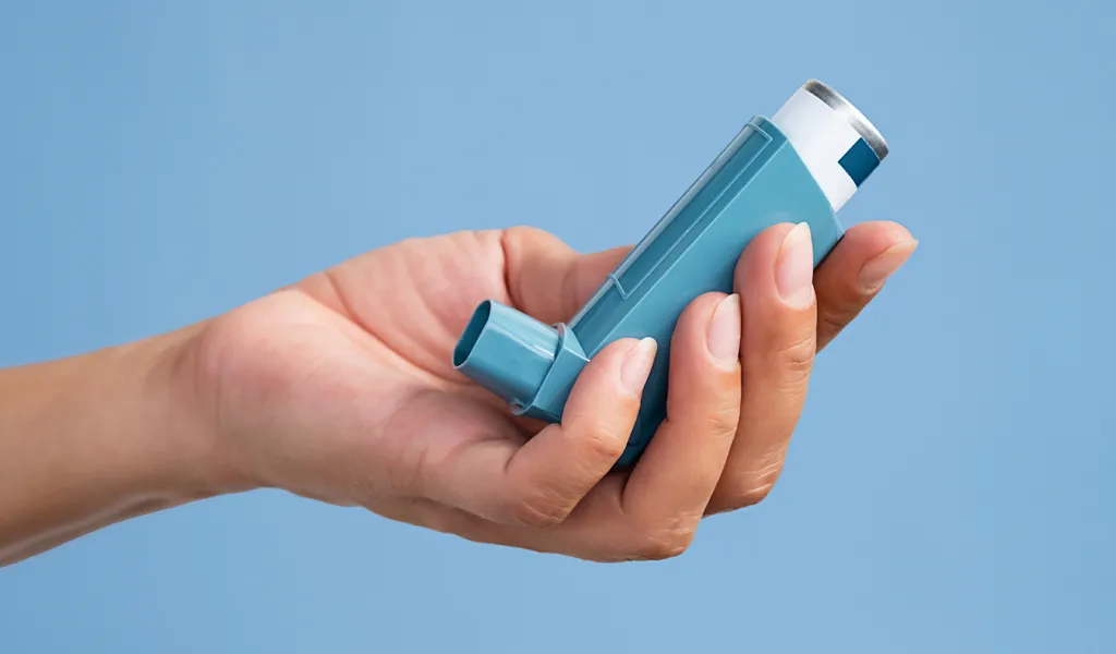 Hand hält einen Dosierinhalator