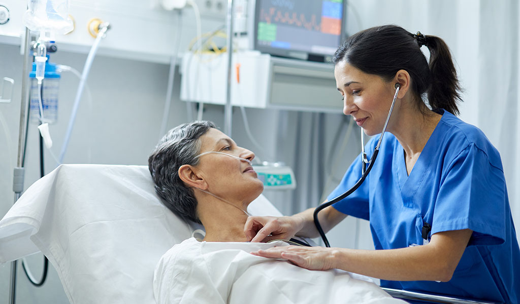 Krankenschwester hört Herzfrequenz einer Patientin im Krankenhaus ab